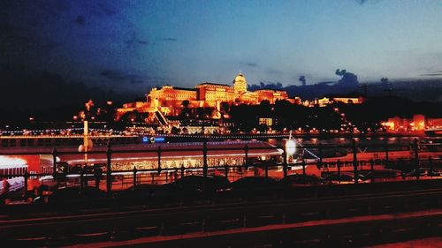 Illuminated cityscape against sky at night