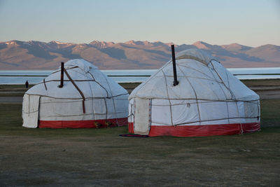 Tent on field by mountain against sky