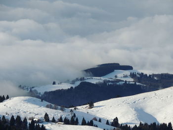 Scenic view of snowcapped mountains against cloudy sky