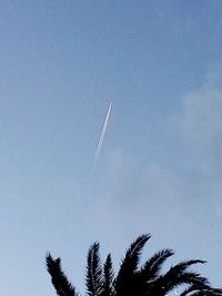 Low angle view of vapor trail against blue sky