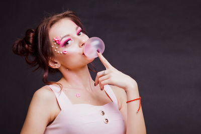 Close-up of beautiful woman against pink background