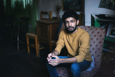 Portrait of young man sitting on chair