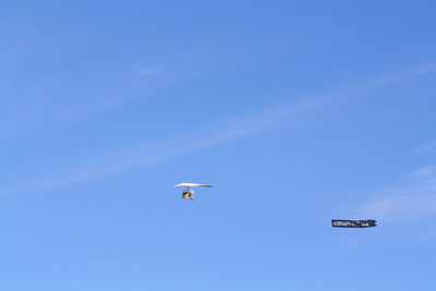 Low angle view of airplane in blue sky