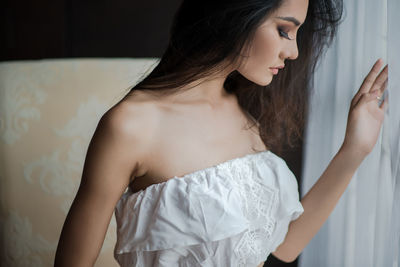 Thoughtful young woman standing at home