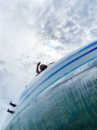 Low angle view of person paragliding against sky