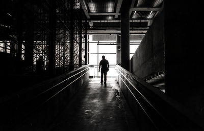 Rear view of silhouette person walking in corridor