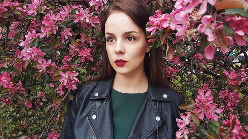 Portrait of young woman with pink flowers