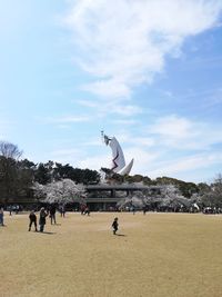 Statue of people on street against sky