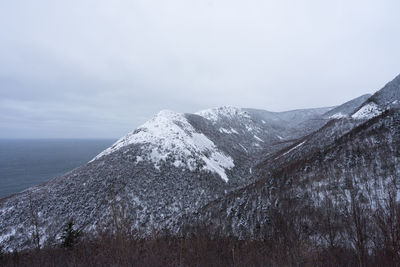 Scenic view of snowcapped mountains and sea against sky