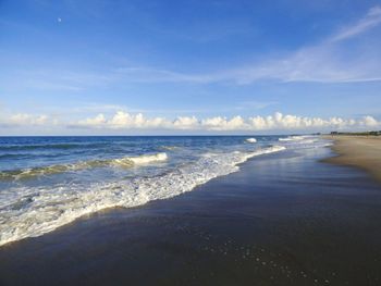 Scenic view of beach against blue sky