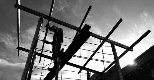Low angle view of silhouette crane against sky at dusk