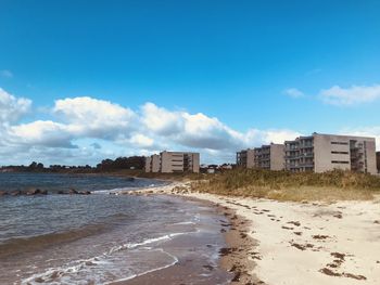 Buildings by sea against sky in city