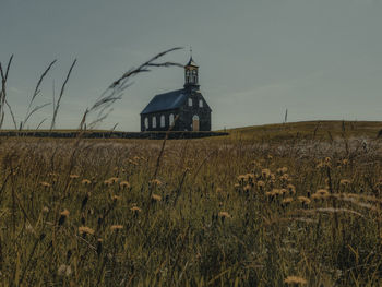 Traditional windmill on field against sky