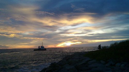 Lone boat in calm sea at sunset