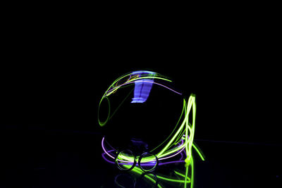 Close-up of illuminated lighting equipment against black background