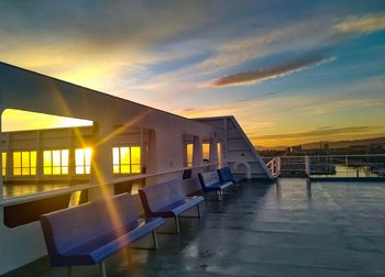 View of swimming pool against buildings at sunset