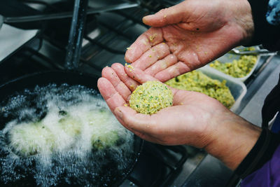 Cropped hands making falafel