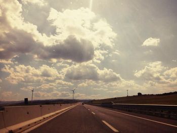 Empty road against cloudy sky