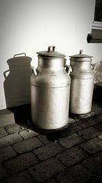 High angle view of milk canisters against wall