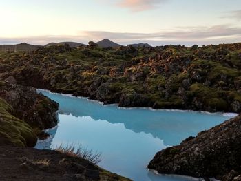 Scenic view of lake by mountains against sky