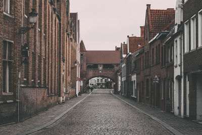 Empty street amidst buildings in city