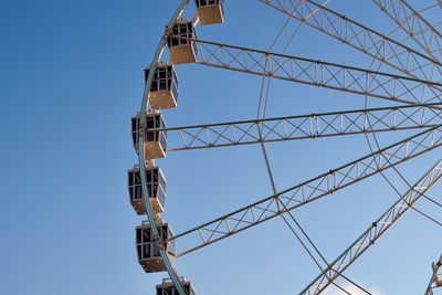 Low angle view of ferris wheel against clear blue sky