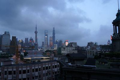 View of cityscape against cloudy sky