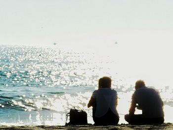 Rear view of two people standing in water