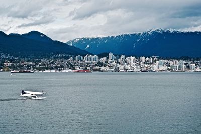 Scenic view of sea by mountains against sky