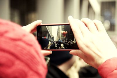 Close-up of woman photographing balloon using mobile phone in carnival