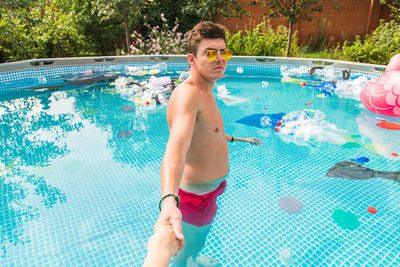 Full length of shirtless man in swimming pool