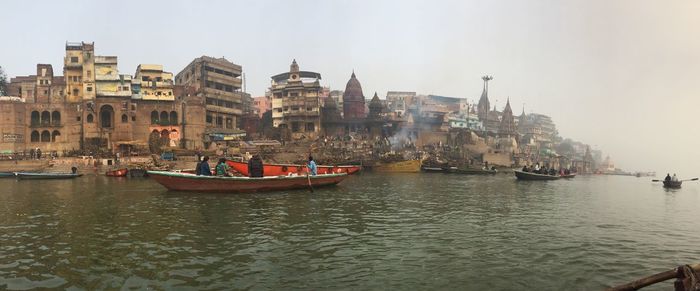 Boats in sea against buildings in city