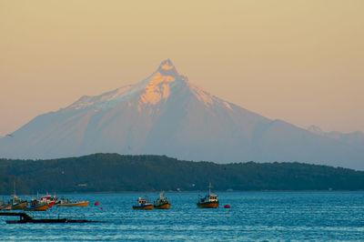 Scenic view of sea and mountains against clear sky