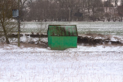 Garbage can on snow covered land