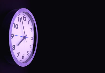 Close-up of clock against black background