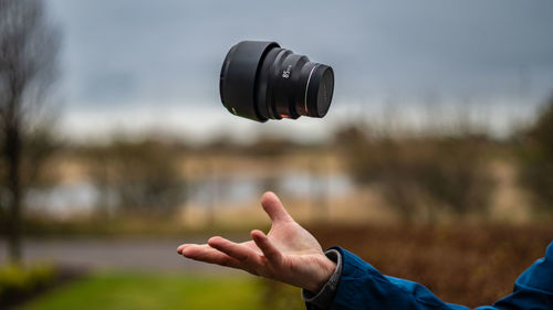 Midsection of man photographing against blurred background