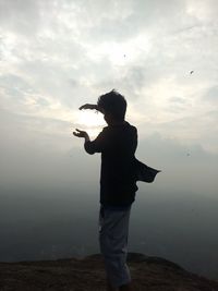 Rear view of man standing against sky