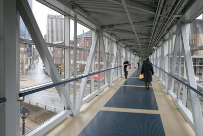 People walking on elevated walkway in building
