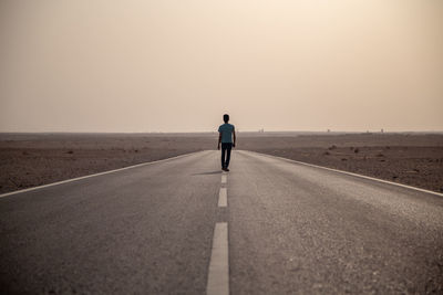 Rear view of man on road against sky