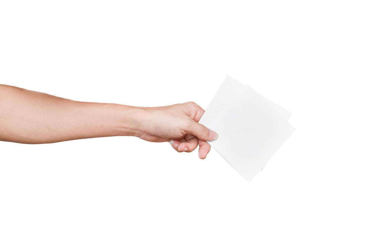 HAND HOLDING PAPER AGAINST WHITE BACKGROUND