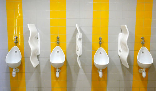 Urinals mounted on wall in public restroom