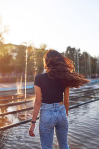Beautiful young woman with flying hair at sunset time