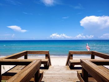 Wooden pier on sea against sky