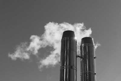 Smoke emitting from chimney against sky