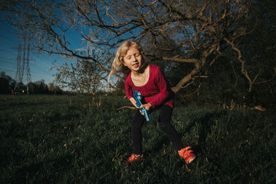 Girl playing with small guitar on field