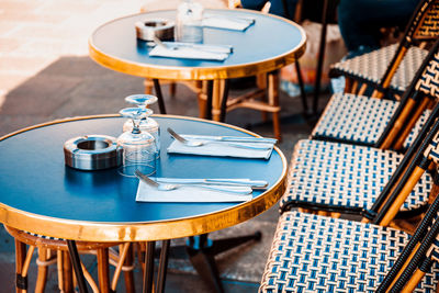 Empty chairs and tables at sidewalk cafe