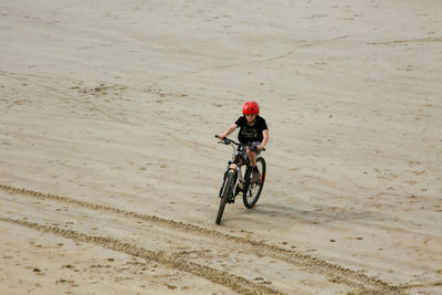 Man riding bicycle on sand