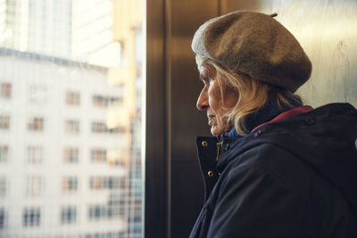 Senior woman looking through window