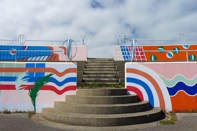 Graffiti on wall by building against sky