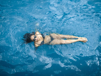 High angle view of young woman swimming in pool